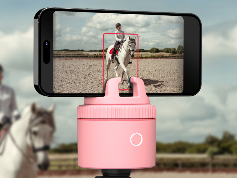 Purple auto-tracking phone holder with 360° rotation mounted on stand, showing remote control and tracking indicators — view 6